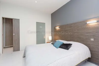 a bedroom with a white bed and a wooden headboard at Clic 20 in Cannes