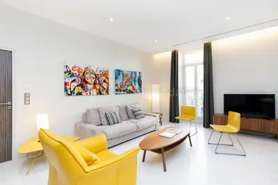 a living room with yellow chairs and a couch at Clic 20 in Cannes