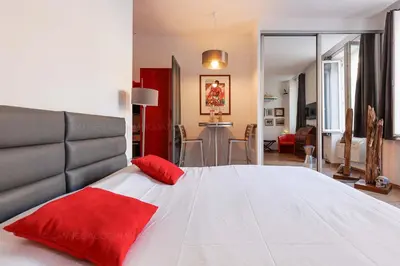 a bedroom with a large bed with red pillows on it at Cruise in Cannes