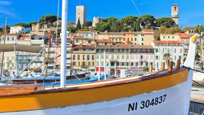 a boat docked in a harbor with buildings in the background at Cruise in Cannes