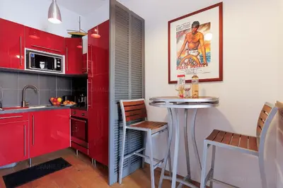 a kitchen with red cabinets and a small bar at Cruise in Cannes
