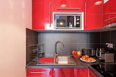 a kitchen with red cabinets and a sink at Cruise in Cannes