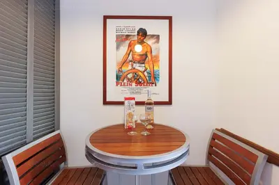 a table with two wine glasses and a poster on the wall at Cruise in Cannes