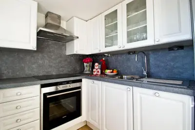 a kitchen with white cabinets and a sink at Victoria in Cannes