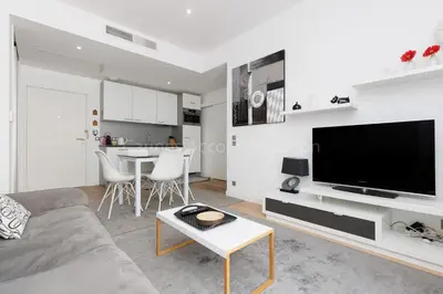 a living room with a couch and a tv and a table at Sparkle in Cannes
