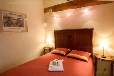 a bedroom with a large orange bed with two pillows at Maillot in Cannes