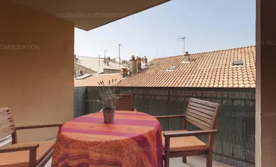 a table with chairs and a vase on a balcony at Lemoine in Cannes