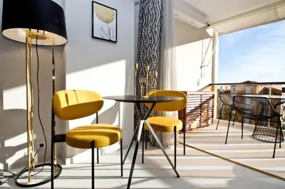 a room with yellow chairs and a table on a balcony at Khayat in Cannes