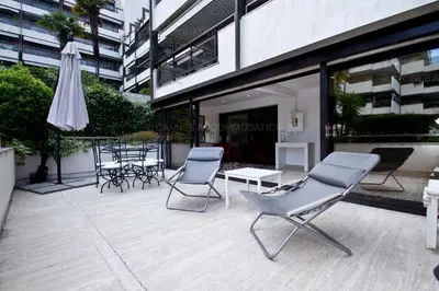 a patio with chairs and an umbrella next to a building at Gray 2A2 in Cannes