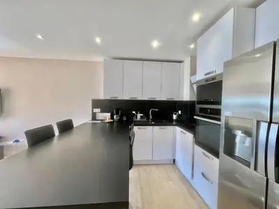 a kitchen with white cabinets and a stainless steel refrigerator at Acanthes by Welcome to Cannes in Cannes