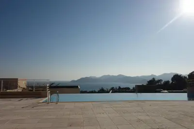 a pool with a view of the water and mountains at Acanthes by Welcome to Cannes in Cannes