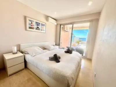 a bedroom with a bed with two black shoes on it at Acanthes by Welcome to Cannes in Cannes