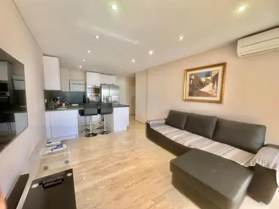 a living room with a couch and a kitchen at Acanthes by Welcome to Cannes in Cannes