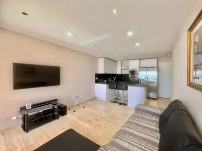 a living room with a couch and a kitchen at Acanthes by Welcome to Cannes in Cannes