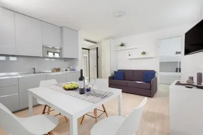 a kitchen and living room with a white table and chairs at Cannes Old Town Suites in Cannes