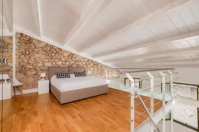 a bedroom with a bed and a stone wall at Cannes Old Town Suites in Cannes