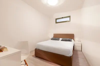 a white bedroom with a bed and a desk at Cannes Old Town Suites in Cannes
