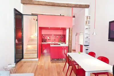 a kitchen with red cabinets and a table with chairs at Festival Apartment in Cannes