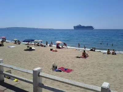 a group of people on a beach with a cruise ship at Festival Apartment in Cannes