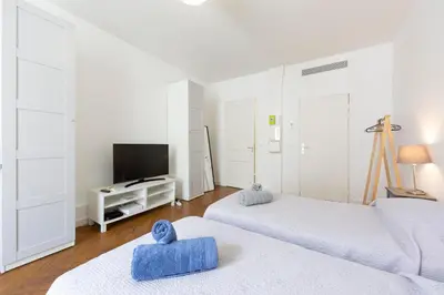 a white room with two beds and a television at Cosy apartment 27 m2 in rue d'Antibes and Croisette in Cannes