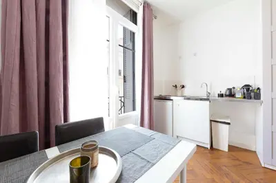 a dining room with a table and a kitchen at Cosy apartment 27 m2 in rue d'Antibes and Croisette in Cannes