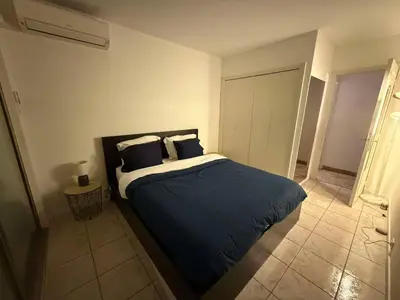 a bedroom with a bed with blue sheets and pillows at 13 Rue Edith Cavell in Cannes