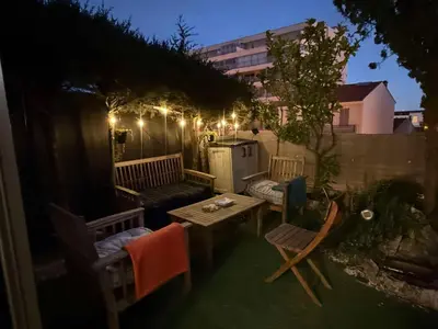 an outdoor patio with a table and chairs at night at 13 Rue Edith Cavell in Cannes