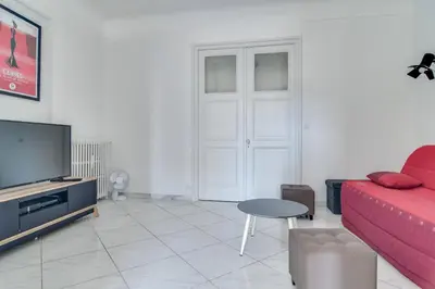 a living room with a red couch and a tv at IMMOGROOM - Sea View - Balcony - 5 min from the beach - AC - Wifi in Cannes