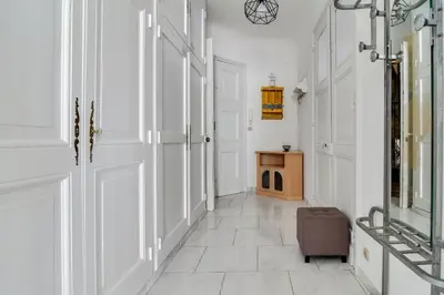 a hallway with white walls and a door and a chair at IMMOGROOM - Sea View - Balcony - 5 min from the beach - AC - Wifi in Cannes