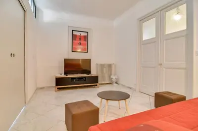 a living room with a bed and a television at IMMOGROOM - Sea View - Balcony - 5 min from the beach - AC - Wifi in Cannes
