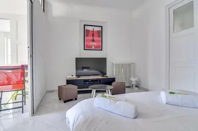 a bedroom with a bed and a desk and a tv at IMMOGROOM - Sea View - Balcony - 5 min from the beach - AC - Wifi in Cannes