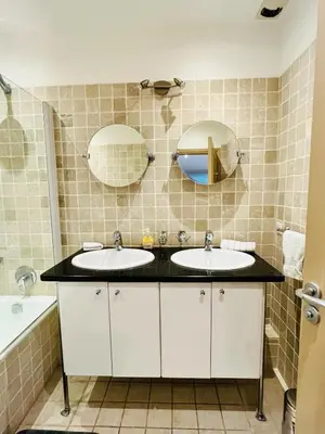 a bathroom with two sinks and two mirrors at Golden Triangle 2Br/2Ba in Cannes