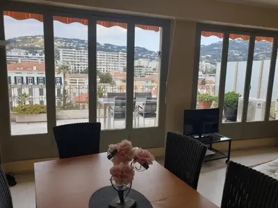 a dining room with a table with a vase of flowers at Cannes Satellite in Cannes