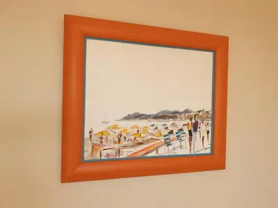 a framed painting of a beach with people at Cannes Satellite in Cannes