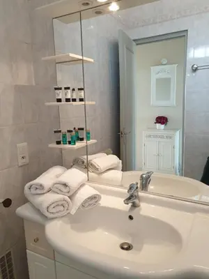 a white bathroom with a sink and a mirror at Cannes Satellite in Cannes