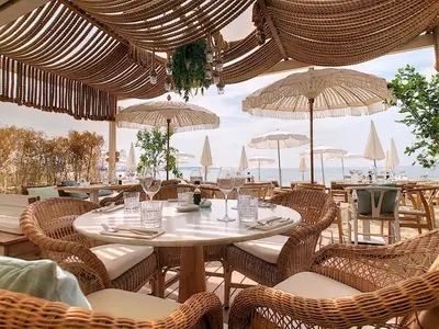 a restaurant with a table and chairs and umbrellas at Luxury Family 2BR - Prime Location, Walk to Beach & Shopping, Sunny Balcony - By Totolulu Cannes Hoche in Cannes