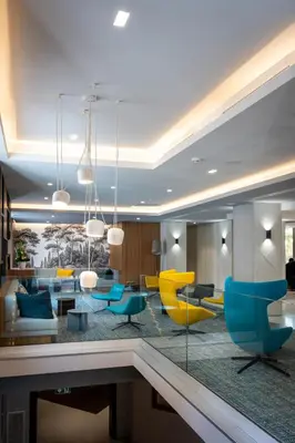 a living room with blue and yellow furniture at Nemea Appart Hotel Cannes Palais in Cannes