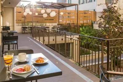 a table with two plates of food on a balcony at Nemea Appart Hotel Cannes Palais in Cannes