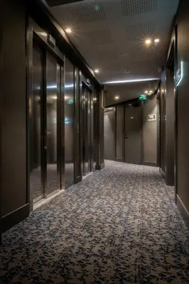 an empty corridor in a building with glass doors at Nemea Appart Hotel Cannes Palais in Cannes