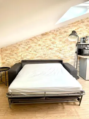 a bed in a room with a brick wall at Safari apartment in heart of Cannes and beaches in Cannes
