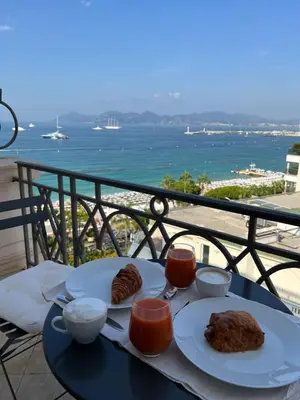 a table with two plates of food on a balcony at Croisette Palais Miramar - sea view in Cannes