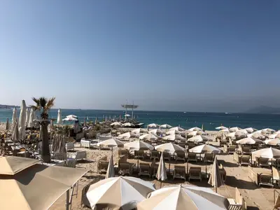 a group of umbrellas and chairs on a beach at Croisette Palais Miramar - sea view in Cannes