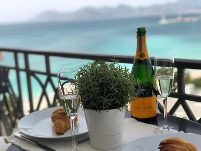 a table with a bottle of wine and a plate of food at Croisette Palais Miramar - sea view in Cannes