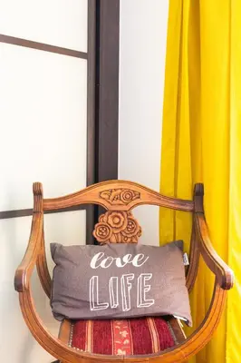 a wooden chair with a love life pillow on it at Villa AD’ALTA in Cannes