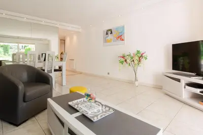 a living room with a couch and a table and a television at Villa AD’ALTA in Cannes