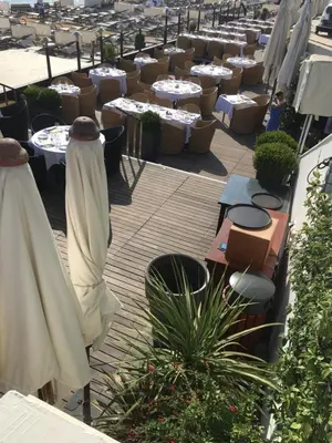 a patio with tables and chairs and plants at Croisette View Lux Flat Cannes in Cannes