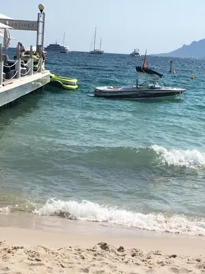 a boat in the water next to a beach at Croisette View Lux Flat Cannes in Cannes