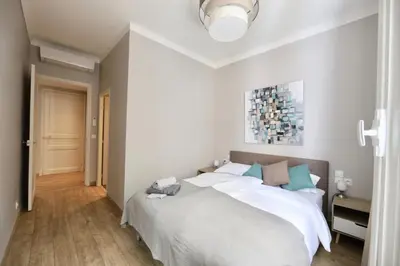 a bedroom with a large bed with white sheets at 70m2 Apartment - La Roseraie in Cannes