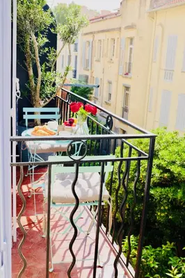a balcony with a table with flowers on it at 70m2 Apartment - La Roseraie in Cannes
