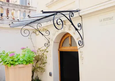 a door to a building with two potted plants at 70m2 Apartment - La Roseraie in Cannes